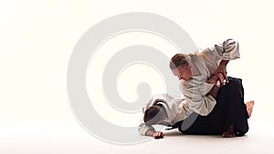 Two guys showing aikido using tanto. Isolated, white. Close up. Close up. Slow motion.