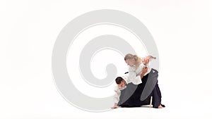 Two guys showing aikido using tanto. Isolated, white. Close up. Slow motion.