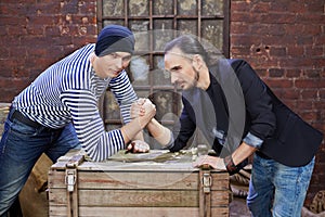 Two guys wrestle on wooden chest