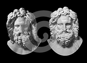 Two gypsum copy of antique statue Zeus head isolated on black background. Plaster sculpture man face with beard.