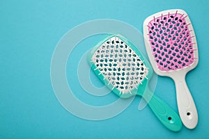 Two hairbrushes on blue background. Flat lay. Space for text