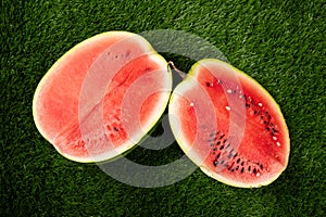 Two half red watermelon on green grass, summer fruitn