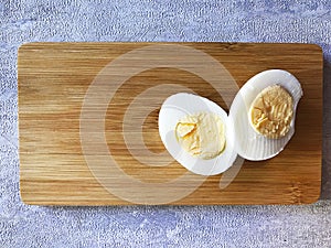 two halves of a boiled egg on a board