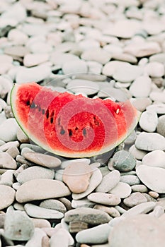 Two halves of cut ripe watermelon on the beach with pebbles