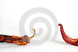 Two halves of dried peppers on a white background