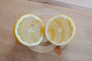 Two halves of lemon on wooden table top