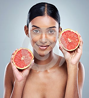 Two halves make on whole lotta goodness. Cropped portrait of an attractive young woman posing in studio against a grey photo