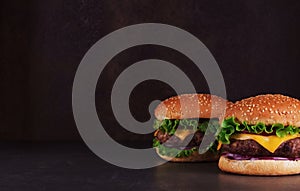 Two hamburgers on dark background with an empty place for an inscription