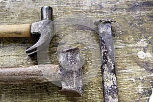 Two hammers lined up on aged wood as a background photo