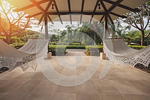 Two hammocks hang under roof photo