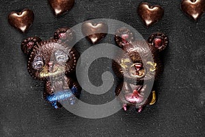 Two hand crafted chocolate bears and many hearts