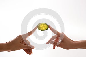 Two hand holding the slice of cucumber on white background