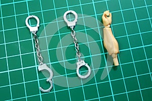 Two Handcuffs miniature with 1:12 Scale Action Figure Arm for Size Comparation on a Cutting Mat photo