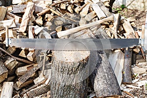 Two-handled saw and ax in chopping block