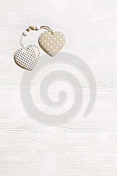 Two handmade hearts from cotton cloth with golden color striped or dots on white wooden background. Valentines Day and