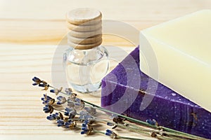 Two handmade soap bars, a bottle of lavender oil and dried lavender.