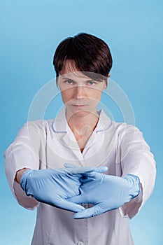 Two hands in blue latex medical gloves joined on a blue background. concept of preparing the doctor for surgery