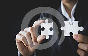 Two hands of businessman to connect couple puzzle piece. symbol of association and connection. business strategy