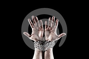 Two hands in chains isolated on black background