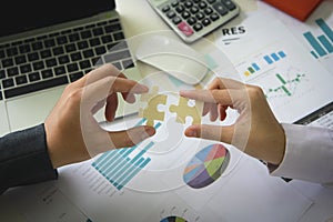 Two hands connect pieces of the puzzle against on table office. Business concept idea, promotion, partnership, cooperation,