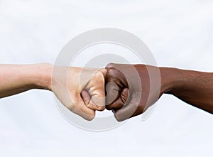 Two hands of different racial colors, punching each other, expressing victory, agreement. The concept of ending racism