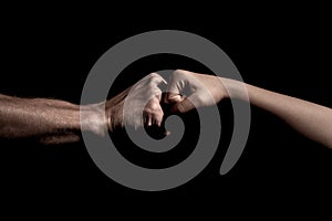 Two hands fist bump together over black background