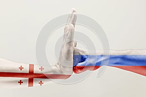 Two hands. Flag of Russian Federation. Flag of Georgia.