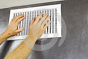 Two Hands in Front of an Air Vent