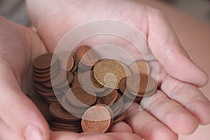 Two hands full of coins. Concept of savings or kid`s pocket money