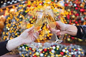 Two hands with glasses of champagne on a Christmas or New Year background