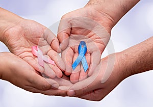 Two hands holding two Pink and Blue ribbons for the Pink October and Blue November campaigns to support life and raise awareness photo