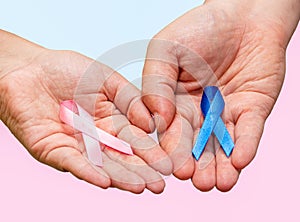 Two hands holding two Pink and Blue ribbons for the Pink October and Blue November campaigns to support life and raise awareness photo