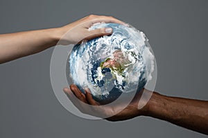 Two hands holding planet Earth, close up. Environment save, taking care of nature and ecology, supporting hands concept