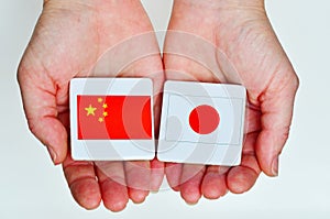 Two hands holds the national flags of the Republic People of Chi