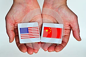 Two hands holds the national flags of the United States of America (L) and of the Republic People of China (R)