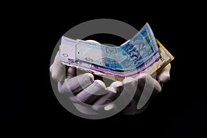 two hands with hryvnias. Closeup female hand giving money for something with isolated on black background,count, paying, shopping