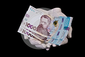 two hands with hryvnias. Closeup female hand giving money for something with isolated on black background,count, paying, shopping