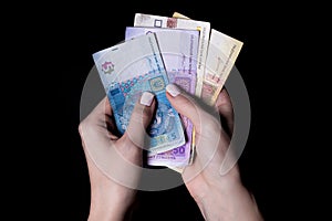 two hands with hryvnias. Closeup female hand giving money for something with isolated on black background,count, paying, shopping