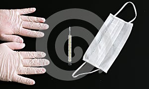 Two hands in latex gloves, thermometer and medical mask