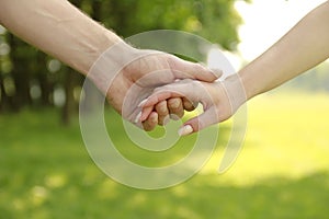 Two hands of a loving couple on nature