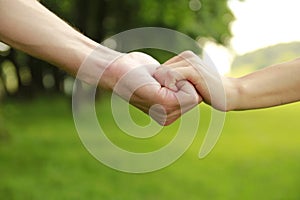 Two hands of a loving couple on nature