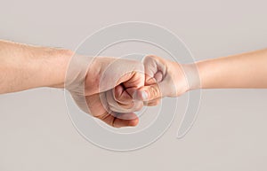 Two hands: man and child. Father and son touching fists. Old man and kid holding hands together. Little and big fists of