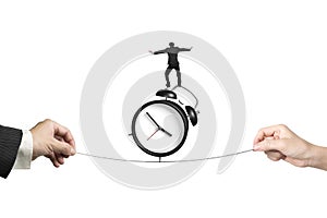 Two hands pulling rope businessman balancing on alarm clock