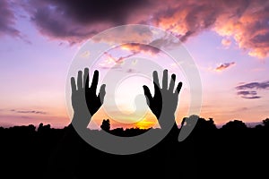 Two hands raised silhouette at sunset, Halloween concept