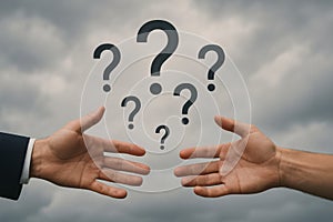 Two hands reaching with floating question marks against cloudy sky symbolizing confusion and inquiry