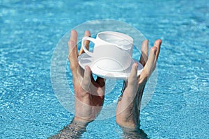 Two hands saving a cup and saucer
