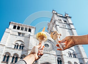 Two hands takes ice cream nearthe San Lorenco Cathedral