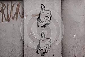Two hands with thumb up drawn on a wall