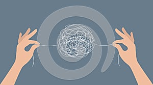 Two hands untangling a ball of thread. Problem solving concept