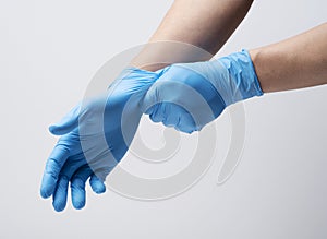 Two hands wearing nitrile gloves on a white background